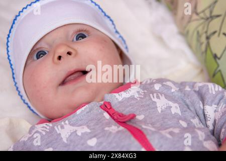 Das kleine Mädchen liegt in der Wiege und lächelt Stockfoto