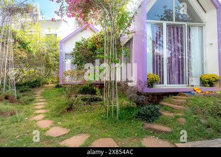 Stadt Gia Nghia, Provinz Dak Nong, Vietnam - 14. Februar 2024: Ein kleines Haus im Garten mit großen Bäumen auf dem grünen Rasen bringt einen friedlichen und hap Stockfoto