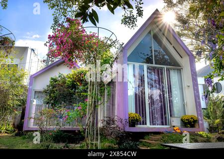 Stadt Gia Nghia, Provinz Dak Nong, Vietnam - 14. Februar 2024: Ein kleines Haus im Garten mit großen Bäumen auf dem grünen Rasen bringt einen friedlichen und hap Stockfoto