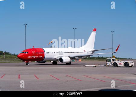 Eine boeing 737-800 von norwegischen Fluggesellschaften in typischer rot-weißer Lackierung am Flughafen Göteborg landvetter, mit dem Pushback-Truck in der Nähe. Helles s Stockfoto