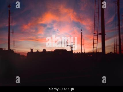 Dampfzüge gegen untergehende Sonne, British Rail, in den 1960er Jahren, West Yorkshire, Nordengland, UK Stockfoto