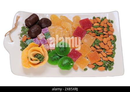 Marmelade, kandierte Früchte, Mango, Kiwi, Nüsse, Samen, Schokoladenbonbons und türkisches Vergnügen in einem Teller. Auswahl an süßen Desserts auf Teller. Stockfoto