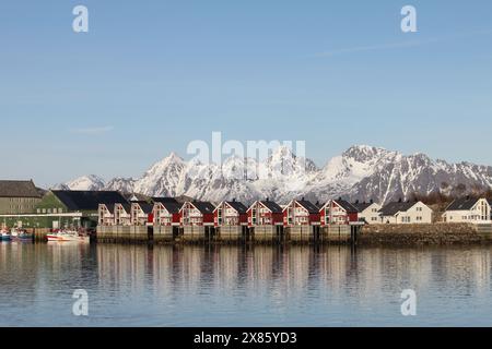 Svolvaer, Norwegen-14. April 2019: Malerischer Blick auf aufeinandergereihte rote Häuser und Fischerboote am Ufer der kleinen Stadt Svolvaer auf den Lofoten Stockfoto