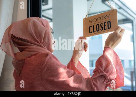 Glücklicher Geschäftsinhaber, der ein offenes Schild in einem Café aufgehängt hat Stockfoto
