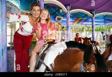 Karin Thaler, deutsche Schauspielerin, mit Kindern unterwegs in der Ponyreitring auf dem Jahrmarkt, Deutschland 2002. Stockfoto