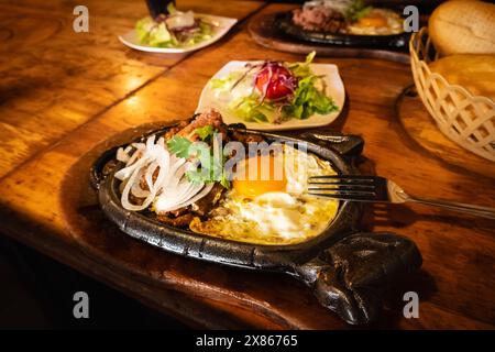 Bo ne trung, Rindfleisch auf einer heißen Platte mit Soße und Eiern, vietnamesisches Frühstück. Bo ne, ein traditionelles vietnamesisches Frühstück mit Steak, Eiern und bague Stockfoto