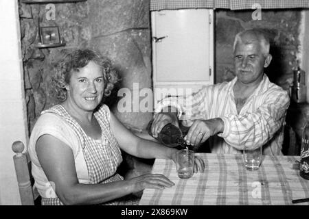 Eine Frau und ein Mann sitzen Abends bei einem Schnaps zusammen, Batcelona 1957. Eine Frau und ein Mann sitzen abends bei einem Schnaps zusammen, Batcelona 1957. Stockfoto