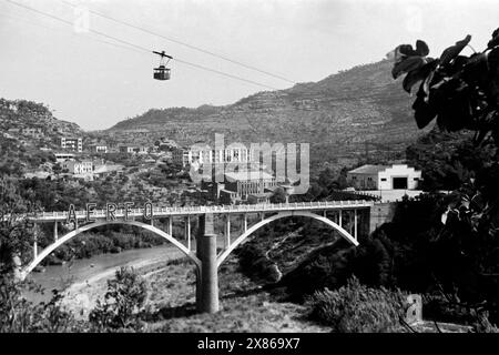 Eine Seilbahn befördert Besucher vom Fuße des Montserrat über den Fluß Llobregat zur Abtei von Montserrat, Katalonien 1957. Eine Seilbahn bringt die Besucher vom Fuße des Montserrat über den Fluss Llobregat zur Abtei Montserrat, Katalonien 1957. Stockfoto