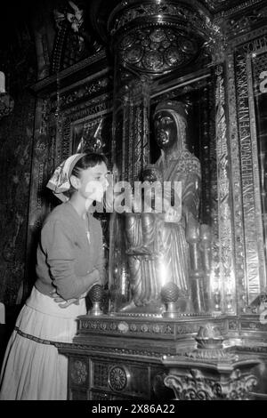 Die Schwarze Madonna von Montserrat ist ein beliebtes Ziel von Pilgern und Bittstellern, die Universumskugel in der rechten Hand der Figur berühren oder küssen, Montserrat 1957. Die Schwarze Madonna von Montserrat ist ein beliebtes Ziel für Pilger und Bittsteller, die die Sphäre des Universums in der rechten Hand der Figur, Montserrat 1957, berühren oder küssen. Stockfoto