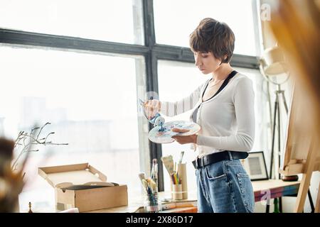 Eine begabte Frau steht in einem Raum und malt. Stockfoto