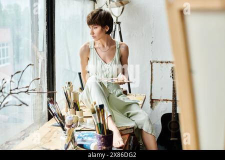 Eine Frau sitzt friedlich auf einem Stuhl und hält eine Palette. Stockfoto