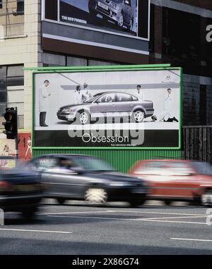 Autokultur: Autos, die Werbung für neue Autos passieren, Great Ancoats Street, Manchester. Stockfoto