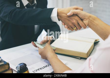 Geschäftsmann-Handshake und Dollarscheine in Händen. Unehrliches Betrügen im Geschäft illegales Geld, Bestechung und Korruption. Bankkunden kommen Stockfoto