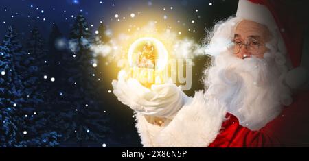 Weihnachtsmann mit glühender Schneekugel im Winterwald. Weihnachtszauber. Bannerdesign Stockfoto