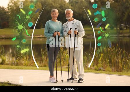 Senior Mann und Frau mit Gehstöcken draußen umgeben von gezogenen Viren. Gesunder Lebensstil - Basis der starken Immunität Stockfoto