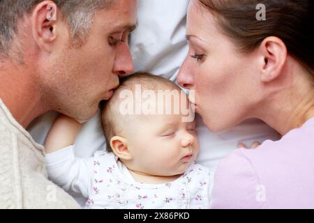 Eltern liegen mit neugeborenem Baby Stockfoto