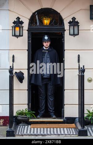 London, UK - 4. März 2024: Eine Person, die als Polizist gekleidet ist, steht am Eingang des Sherlock Holmes Museum in der Baker Street in London. Stockfoto