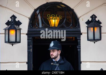 London, UK - 4. März 2024: Eine Person, die als Polizist gekleidet ist, steht am Eingang des Sherlock Holmes Museum in der Baker Street in London. Stockfoto