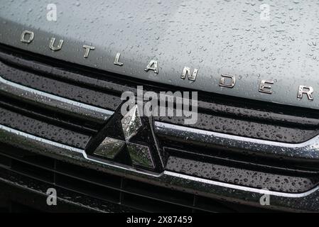 Kiew, Ukraine - 24. Mai 2024. Mitsubishi Outlander-Schild auf dem Kühlergrill eines Autos mit Wassertropfen. Stockfoto