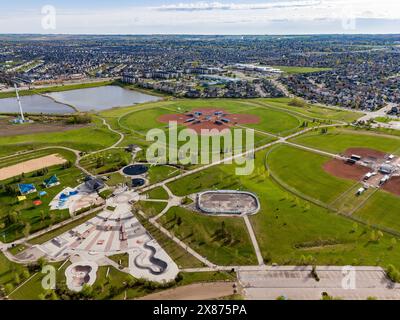 Airdrie Alberta Canada, 21. Mai 2024: High Aerial Chinook Winds Park mit Blick auf Baseballdiamanten und entfernte Regenwasserrückhaltebecken. Stockfoto