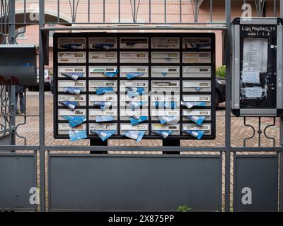 Cremona, Italien - 5. Mai 2024, mehrere Briefkästen gefüllt mit überfüllten Briefen und Anzeigen, die eine gemeinsame Szene in einer Wohnwohnung darstellen Stockfoto