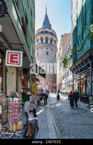 Istanbul, Türkei - 13. Mai 2023: Beliebtes Touristenziel Galata Tower, aus der engen und atmosphärischen kopfsteingepflasterten Buyuk Hendek Street Stockfoto