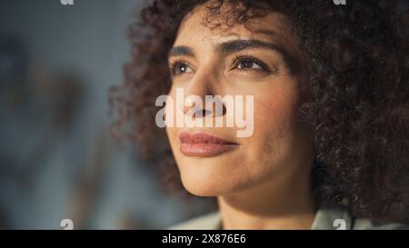 Nahaufnahme Porträt einer schönen kreativen Spezialistin mit lockigem Haar. Junge erfolgreiche multiethnische arabische Frau, die im Kunststudio arbeitet. Träumen von einem besseren Leben und Chancen, die vor uns liegen. Stockfoto