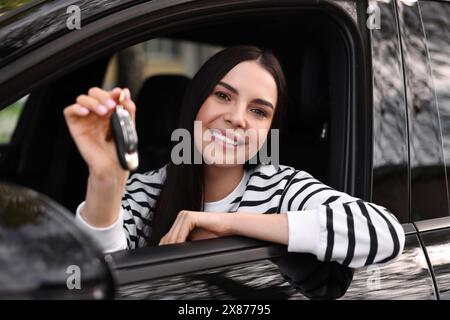 Eine Frau, die den Klappschlüssel in ihrem Fahrzeug hält Stockfoto