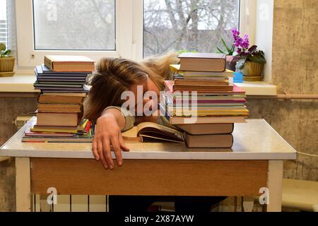 Die junge Frau hat es satt, Wissenschaft zu studieren, schlief am Tisch ein. Hochwertige Fotos Stockfoto