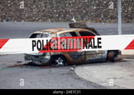 Auto verbrannt von einem Pyromanen mit einem Polizeiband, in dem es auf Französisch "Police nationale" geschrieben ist. Stockfoto