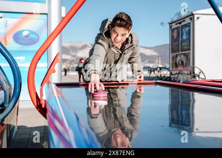 Glücklicher Junge, der Air Hockey spielt Stockfoto