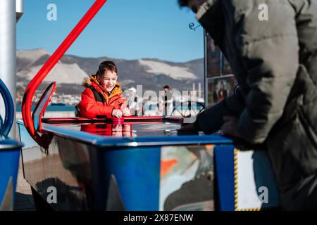 Glücklicher Junge, der mit Bruder Air Hockey spielt Stockfoto