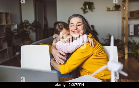 Lächelnde Großmutter und Enkelin umarmen sich zu Hause Stockfoto