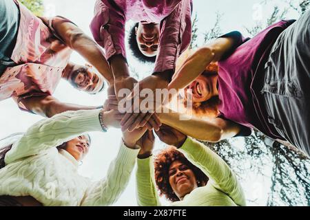 Multirassische Freunde stapeln Hände im Park Stockfoto