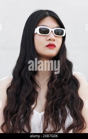 Modische Frau mit langen Haaren und Sonnenbrille Stockfoto