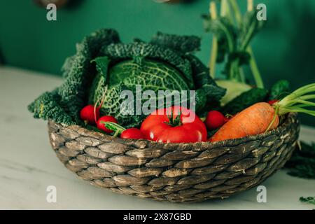 Verschiedene frische Gemüsesorten im Korb auf dem Tisch in der Küche Stockfoto