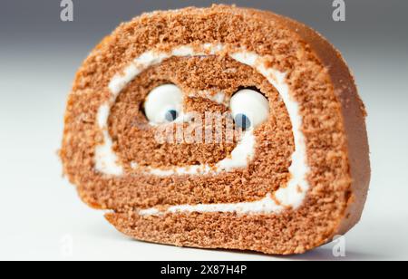 Schokoladenschwammrolle mit Vanillegeschmack, Füllung mit süßen Augen, Schokoladenbrötchen Stockfoto