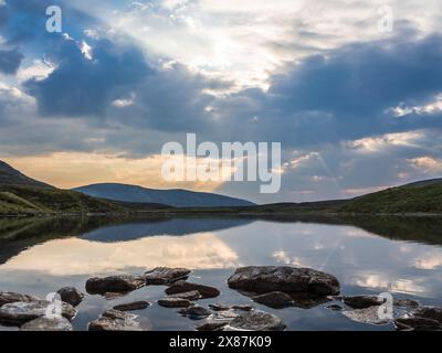 Großbritannien, Schottland, Lake in Cairngorm Mountains bei bewölktem Sonnenaufgang Stockfoto