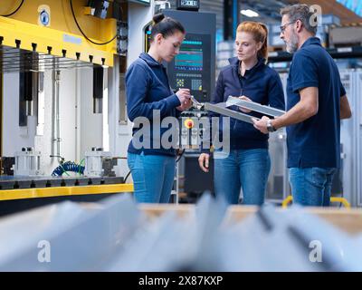 Multirassische Ingenieure diskutieren bei Treffen in der Industrie über Ausrüstung Stockfoto