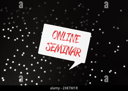 Ein weißes und rotes Schild mit den Worten Online Seminar in Rot. Das Schild ist von einem Sternmuster umgeben Stockfoto