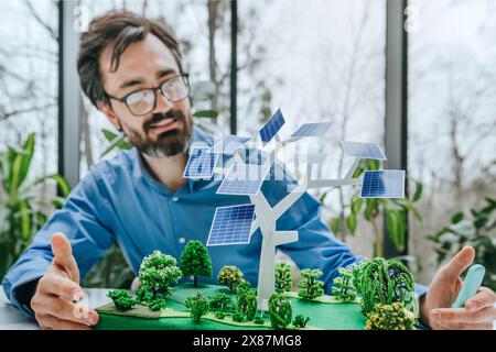 Lächelnder Geschäftsmann, der im Büro am Solarbaum-Projekt arbeitet Stockfoto