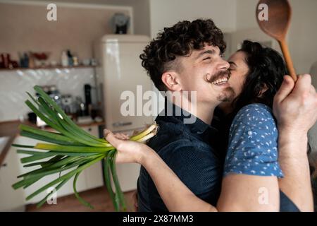 Glückliches Paar umarmt in der Küche zu Hause Stockfoto