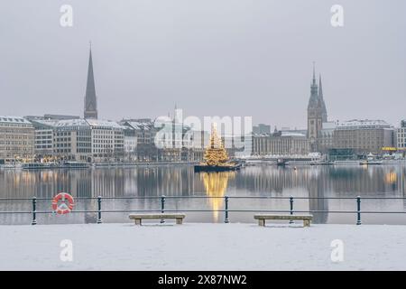 Deutschland, Hamburg, Binnenalster im Winter von der schneebedeckten Brücke aus gesehen, mit einem Weihnachtsbaum im Hintergrund Stockfoto