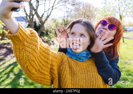 Glückliche Tochter, die Selfie mit Mutter im Park macht Stockfoto