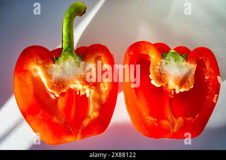 Eine rote Paprika, in zwei Scheiben geschnitten. Stockfoto