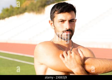 Der Athlet erwärmt sich durch Dehnen vor dem Training. Mann macht Dehnungsübungen vor dem Training Stockfoto
