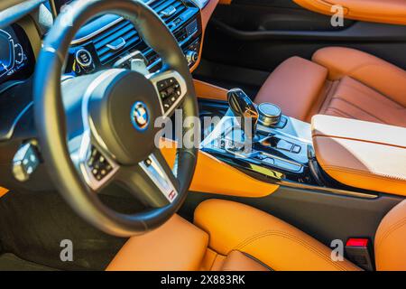 Nahaufnahme des Innenraums des BMW i4 Elektroautos mit orangefarbenen Ledersitzen. Stockfoto