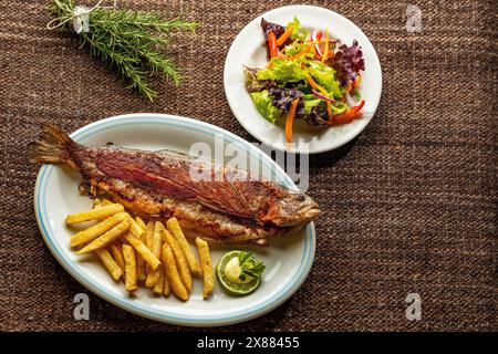 Gebackene Forelle mit Pommes Frites - Regenbogenforelle vom Tota Boyaca See. Kolumbianische Gastronomie Stockfoto