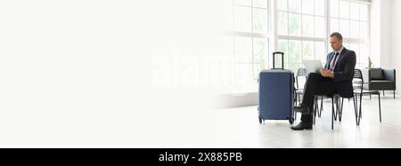 Reifer Geschäftsmann mit Laptop in der Flughafenhalle. Banner für Design Stockfoto