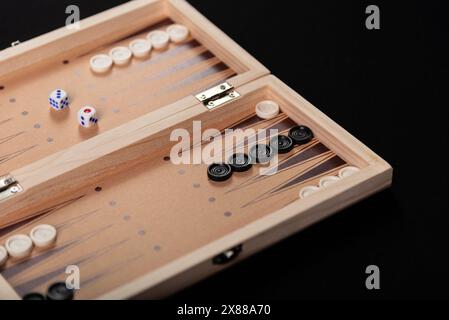 Traditionelles Backgammon-Spiel. Brett mit Backgammon Spielstücken auf schwarzem Hintergrund. Stockfoto